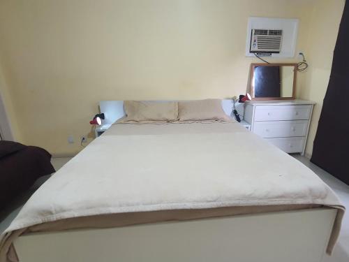 1 dormitorio con 1 cama blanca grande y vestidor en GuestHouse Casa da Montanha, en Río de Janeiro