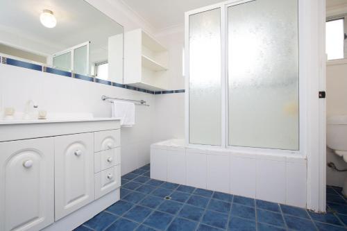 La salle de bains blanche est pourvue d'une douche et de toilettes. dans l'établissement Hillvue Lodge, à Tamworth