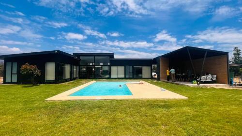 a modern house with a swimming pool in the yard at Parcela Casas Modernas Alto la Campana in Granizo