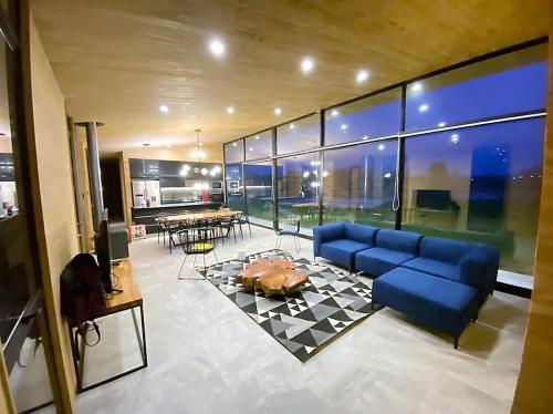 a living room with a blue couch and a table at Parcela Casas Modernas Alto la Campana in Granizo