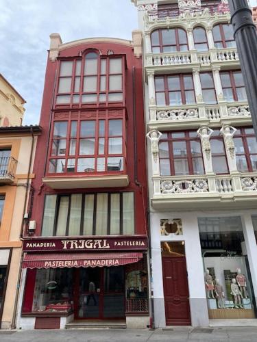a red building with windows on a street corner at NUEVO apartamento céntrico Casa Felipa in Zamora