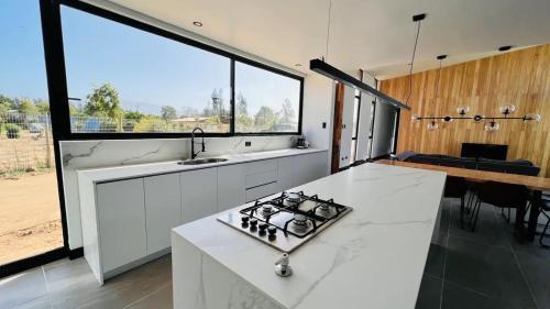 a kitchen with a stove and a large window at Parcela Casas Modernas Alto la Campana in Granizo