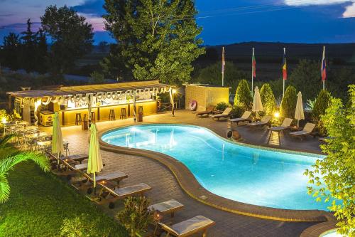 a swimming pool with chairs and umbrellas at night at Sunny Hill in Sani Beach