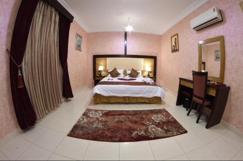 um quarto com uma cama, uma secretária e um espelho em شقق النخيل em Ar Rass