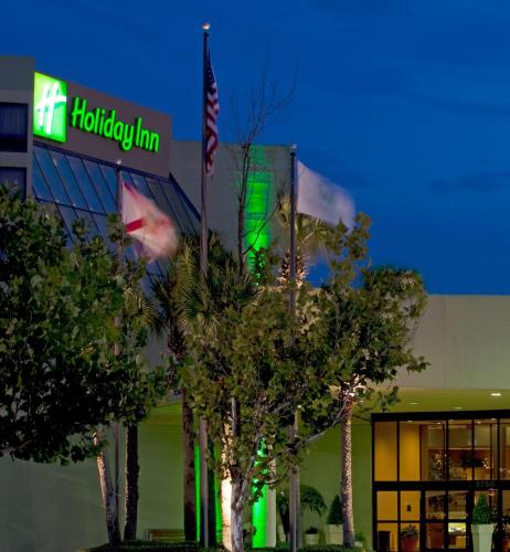 a building with an american flag in front of it at Holiday Inn Orlando International Airport by IHG in Orlando