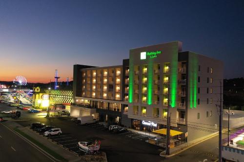 a hotel building with green lights on it at night at Holiday Inn & Suites Pigeon Forge Convention Center by IHG in Pigeon Forge