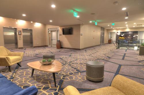 a lobby with couches and a table and a tv at Holiday Inn & Suites Pigeon Forge Convention Center by IHG in Pigeon Forge