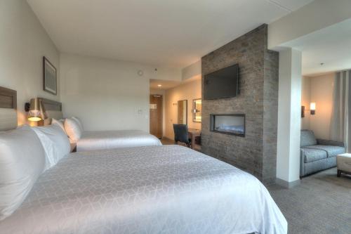 a hotel room with two beds and a fireplace at Holiday Inn & Suites Pigeon Forge Convention Center by IHG in Pigeon Forge