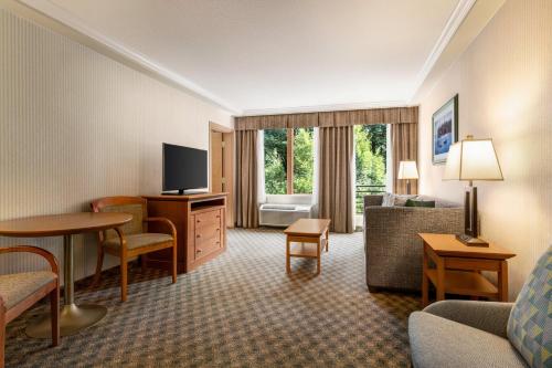 a hotel room with a couch and a television at Holiday Inn & Suites North Vancouver by IHG in North Vancouver