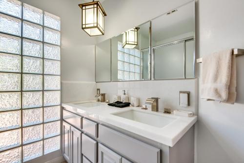 a white bathroom with a sink and a mirror at Lake Balboa Home with Scenic Patio Near Van Nuys! in Van Nuys