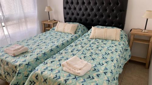 ein Bett mit zwei Kissen darüber in der Unterkunft Castelli 630 in La Plata