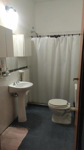 Un baño blanco con inodoro y lavabo. en EL oasis Depto, en Córdoba