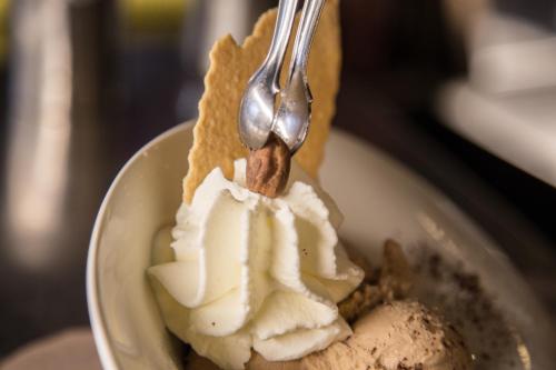 a spoon is digging into a piece of ice cream at Alpenhotel La Montanara in Rocca Pietore