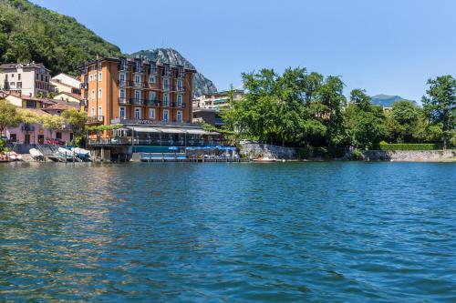 a view of a body of water with buildings at Hotel Riviera in Melide