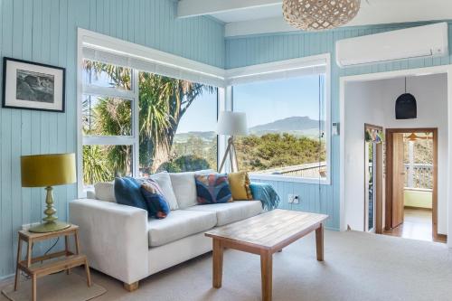 a living room with a couch and a large window at Karioi View in Raglan