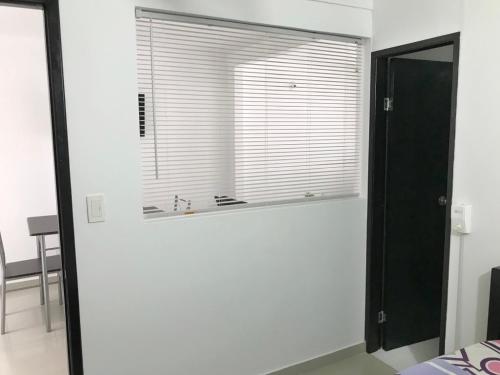 Cette chambre blanche dispose d'une fenêtre et d'un miroir. dans l'établissement Rest 1, à Santa Marta