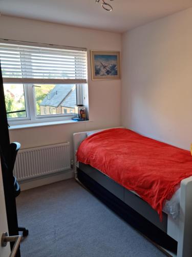 um quarto com uma cama vermelha e uma janela em Trundle bed- with office desk, small room em Newhaven
