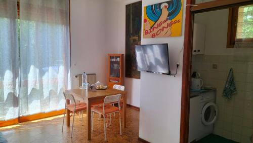 a kitchen with a table and a tv on a wall at Casa con giardino: Varazze in Varazze