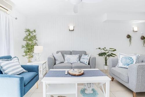 a living room with couches and a coffee table at Sandy Feet Hideaway at Four Mile Beach in Port Douglas