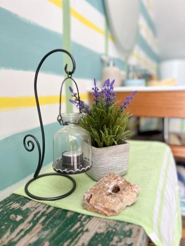 a table with a glass jar and a potted plant at Attico "NIDO" a 50m dal mare con terrazzo grande - un'oasi di pace e bellezza in Nečujam