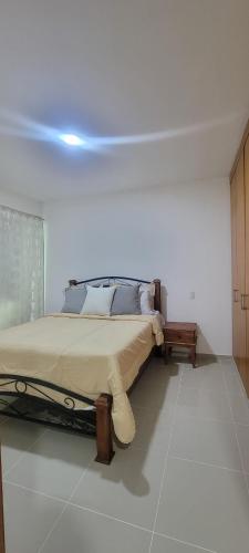 ein Schlafzimmer mit einem Bett in einem weißen Zimmer in der Unterkunft Lomar apartamento en Santo Domingo Este in Ensanche Los Minas