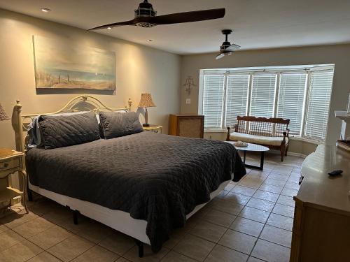 um quarto com uma cama e uma ventoinha de tecto em Surfside Shangri La em Daytona Beach