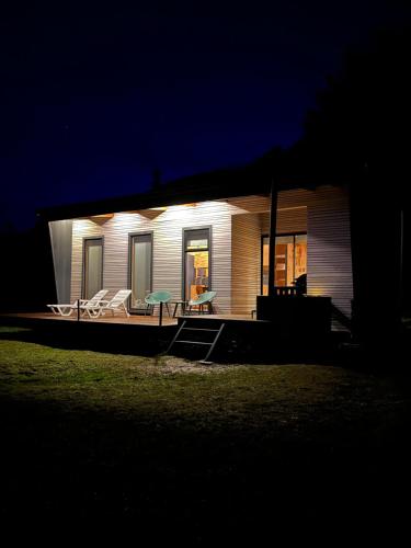 a small house with a patio at night at Aysén Lodge - Cabaña con Tinaja in Puerto Dunn