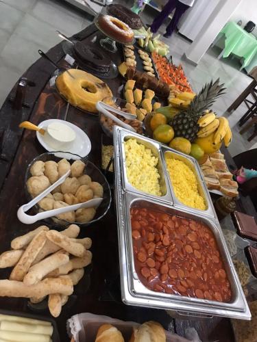 une table garnie de nombreux types d'aliments différents dans l'établissement Pousada Serra Branca, à São Thomé das Letras