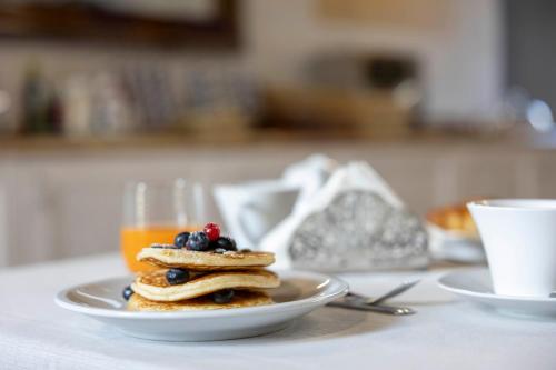 een bord pannenkoeken met bessen en een glas sinaasappelsap bij La Corte San Lorenzo in Moscazzano