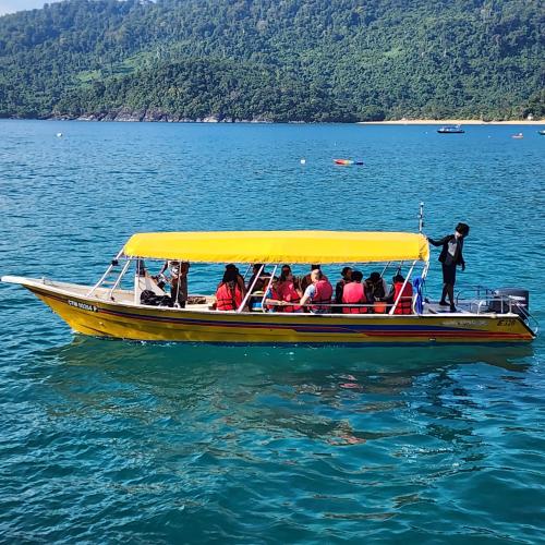 a group of people on a boat in the water at Permai Chalet Tioman in Kampong Juara