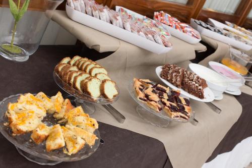 a table with several different types of cakes and desserts at Hotel Esplanade in Cesenatico