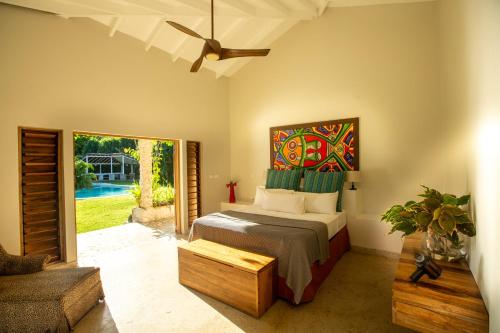 1 dormitorio con 1 cama con una pintura en la pared en Nakatumble - Luxury Sustainable Villa with Farm en Pangona