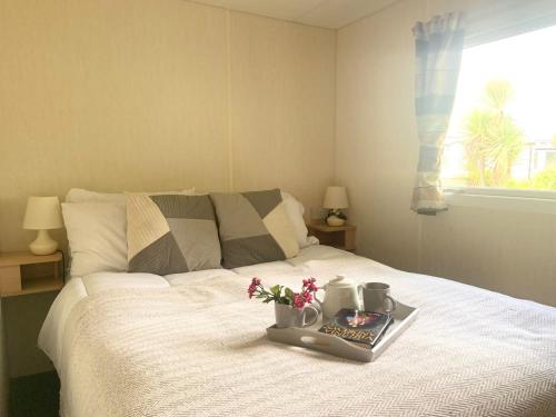 a bedroom with a bed with a tray with flowers on it at The Beeches in Lincolnshire