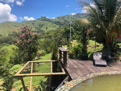 une terrasse en bois avec un bassin profond dans un jardin dans l'établissement Gopal Ecolodge (ecofinca), à Barbosa