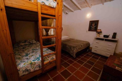 a bedroom with two bunk beds and a desk at Gopal Ecolodge (ecofinca) in Barbosa