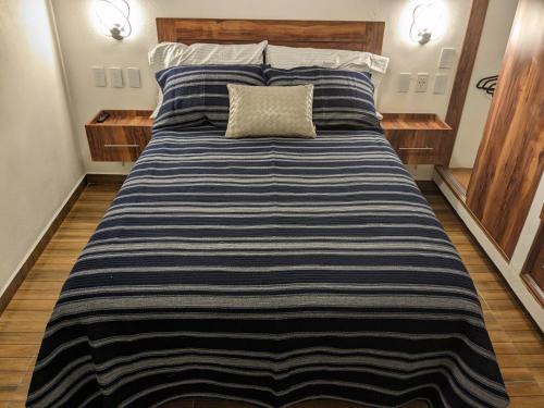 1 cama grande con edredón de rayas azul y blanco en Suite Palma, Experiencia Única, Nómadas Digitales, Home Office o Vacacional, en Tepotzotlán