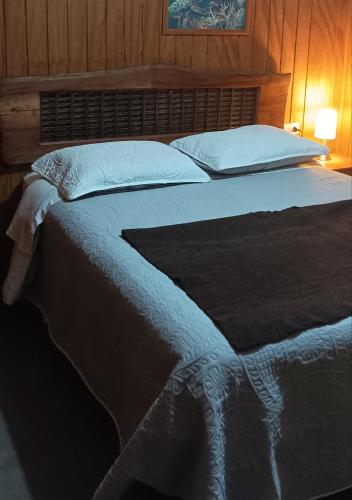 - une chambre avec un grand lit et une tête de lit en bois dans l'établissement Casa Turística Arauco, à Arauco