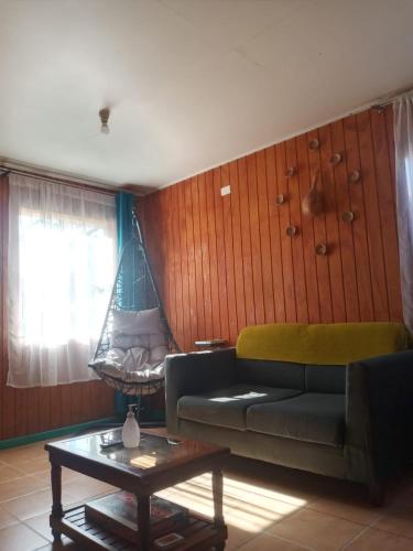 Casa Turística Arauco في أراوكو: غرفة معيشة مع أريكة وأرجوحة