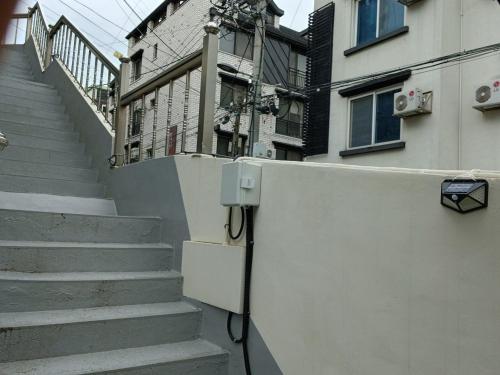 un edificio con escaleras y una pared con una farola en Elle House 2, en Jeonju