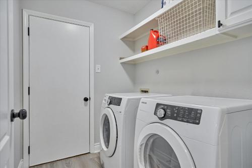a laundry room with a washer and dryer at Woodlands Contemporary 4BR3Bath with heated Pool and Spa in The Woodlands