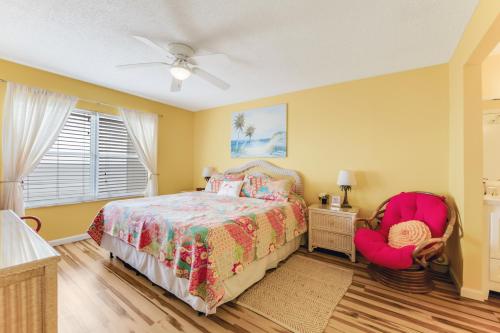 um quarto com uma cama e uma cadeira em Updated Oceanfront Condo! Come Relax by the Sea! em Ormond Beach