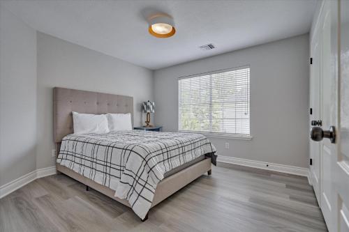 a bedroom with a bed and a window at Woodlands Contemporary 4BR3Bath with heated Pool and Spa in The Woodlands