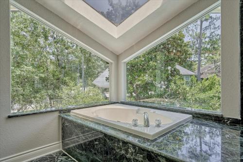 a bathroom with a sink and two large windows at Woodlands Contemporary 4BR3Bath with heated Pool and Spa in The Woodlands