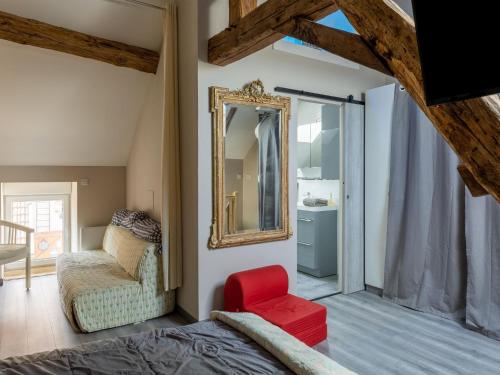 1 dormitorio con cama, espejo y silla en Cottage with independent studio in Molesme, en Villiers-les-Moines