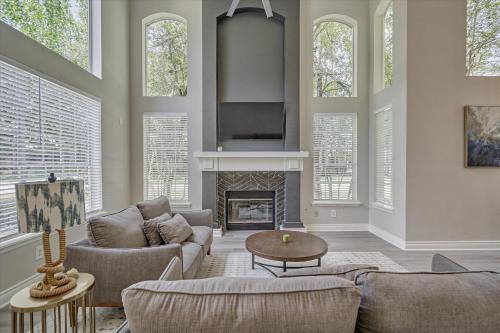a living room with a couch and a fireplace at Woodlands Contemporary 4BR3Bath with heated Pool and Spa in The Woodlands