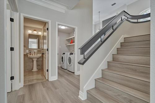 a staircase in a house with a bathroom and a sink at Woodlands Contemporary 4BR3Bath with heated Pool and Spa in The Woodlands