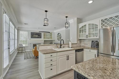 a kitchen with white cabinets and stainless steel appliances at Woodlands Contemporary 4BR3Bath with heated Pool and Spa in The Woodlands