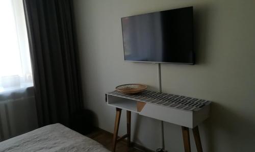 a room with a tv on a wall with a table at Apartment Vilnius Zemaitijos in Vilnius