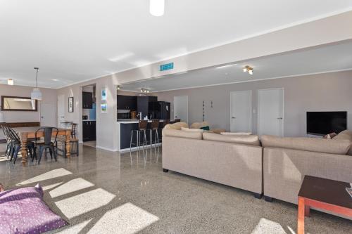 a living room with two couches and a dining room at Surf n Sand n Summer Vibes in Waiotahi