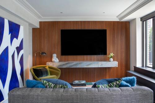a living room with a couch and a television at JW Marriott Essex House New York in New York
